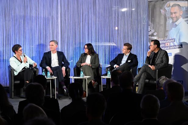 Podiumsdiskussion mit fünf Personen auf einer Bühne, alle sitzen in Sesseln. Im Hintergrund ist ein Banner der Investitions- und Strukturbank Rheinland-Pfalz (ISB) sichtbar